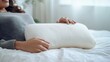 © dlu - A person resting their elbow on a pillow in a serene bedroom after an injury. Featuring comfort and recovery