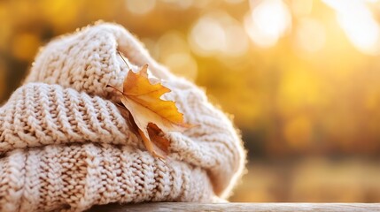 Poster - Cozy knitted beige hat adorned with a golden autumn leaf in soft sunlight : Generative AI