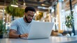 © Generative AI - Young man working on a laptop in a cozy modern office environment reflecting productivity and focus : Generative AI