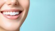 © artchvit - Oral care gum protection essential. Close-up of a smiling woman with bright, white teeth against a blue background.