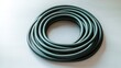 © Iurii - Large coiled garden hose arranged on a light grey surface with soft lighting