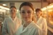 © Vooglo.com - A portrait of three female scientists standing close together in a laboratory, all wearing white lab coats and protective glasses