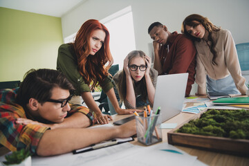 Photo of lovely young people tired nervous team look netbook startup teambuilding comfortable startup office loft room interior