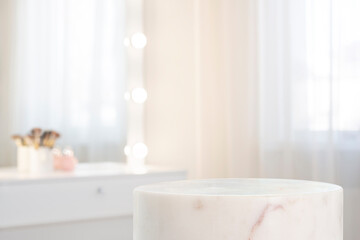 Wall Mural - white marble pedestal of cylinder shape for cosmetic product display on blurred dressing room interi