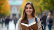 © Oleksandr Butenko - smiling young female college student holding a book