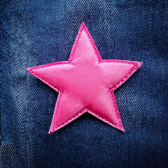 Wall Mural - Close-up of a Pink Star Patch Sewn onto Blue Denim Fabric