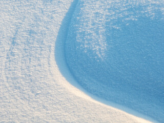 Wall Mural - beautiful winter background with snowy ground. natural snow texture. wind sculpted patterns on snow 