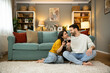 © Dejan - An intimate moment shared between a couple over a glass of wine, radiating warmth and joy in their cozy living space.