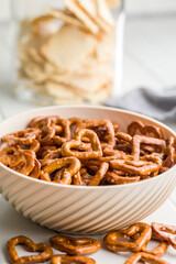 Canvas Print - Heart shaped pretzel in bowl  on white table.