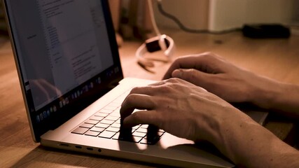 Canvas Print - close-up of the hands of a male it programmer typing on a laptop keyboard while looking at a monitor