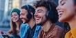 © peerawat - A cheerful scene of a group of friends enjoying music together, sharing headphones connected to a device