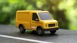 © WATMA_COLLECTIONS - Yellow delivery van toy on road, nature background, for children's play