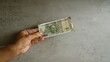 © Krakenimages.com - Hand holding indian 500 rupee note on concrete background, illustrating currency concept.