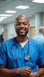 © deFusum - Smiling male doctor in blue scrubs with stethoscope in hospital