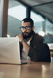 © N F/peopleimages.com - Laptop, thinking and research with business man in office for web designer, ux tools or planning. Coding homepage, night and developer with person in tech agency for cms platform, glasses and reading