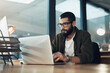 © N F/peopleimages.com - Laptop, typing and research with business man in office for web designer, ux tools or planning. Coding homepage, night and developer with person in tech agency for cms platform, glasses and reading