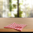 © New Africa - Red checkered tablecloth on wooden table in room, closeup