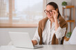 © Pixel-Shot - Beautiful young happy woman in new eyeglasses with laptop sitting at home