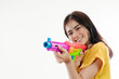 © Kibum - Beautiful smiling Thai woman holding a colorful water gun against white background in studio photography setting with professional color grading.