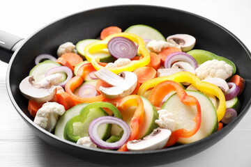 Poster - Frying pan with mix of vegetables and mushrooms on white table, closeup