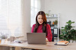 © David - Young Asian girl or Asian businesswoman working at home office with a laptop