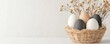 © IYearDesign - Easter egg basket in spring decoration A woven basket holds decorative eggs with dried flowers against a neutral background.