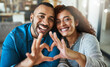 © peopleimages.com - Hands, heart and portrait of couple in home with gesture for support, commitment and trust. Dating, love and happy man and woman with emoji sign for bonding, relationship and romance together