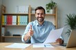 © miss irine - Happy businessman smiles, gives thumbs up. Auditor holds report at desk with laptop in office. Successful manager shows approval, business, accountant reconcile financial report. Broker consults