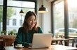 © miss irine - Asian young woman works at laptop in cafe drinking coffee. Happy japanese student uses computer for distance learning, browsing, communication. Online remote work lifestyle.