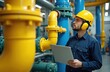 © miss irine - Maintenance technician in blue uniform with laptop supervises gas pipelines in factory. Engineer in hard hat, noise cancelling headphones monitors piping system, ensures safety, efficient operation
