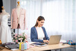 © Wanwajee - Women fashion designer stylish sitting and working with color textile samples and laptop. Attractive young woman working with mannequins and colorful fabrics at fashion studio.
