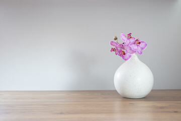 Poster - purple orchid in modern ceramic vase on white  background