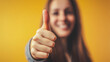 © GrayFrog - Bokeh woman shows thumb up gesture on yellow background