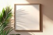 © MrHamster - A picture frame with natural light and a green plant on wall