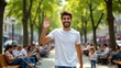 © Leonardo - Hombre joven sonriente saludando alegremente en un bullicioso parque de la ciudad con árboles iluminados por el sol y gente relajándose en los bancos