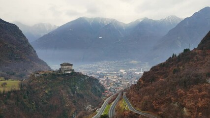 Wall Mural - Building on the hill with a beautiful landscape in the background, filmed in the Italian Alps (drone footage)