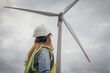 © YURIMA - An engineer keenly observing the ongoing wind turbine installation process at a renewable energy site, ensuring all aspects align with development goals and efficiency standards for the future