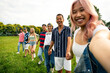© oneinchpunch - Group of multiethnic teenagers spending time outdoor on a picnic at the park