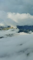 Wall Mural - flying between the clouds. aerial view of clouds and mountains at sunrise. traveling by air backgrou