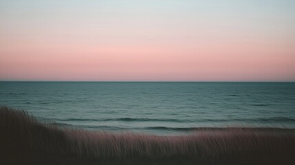 Wall Mural - A tranquil view of the ocean at sunset with soft pastel colors in the sky.