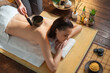 © Acronym - Young woman getting massaging treatment over exotic background. Spa, healthcare and recreation concept.