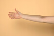 © vladimirfloyd - Minimalist stock photo of extended female arm against neutral beige background. Delicate skin texture and elegant hand positioning in soft natural light