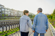© ADDICTIVE STOCK - Elderly couple walking hand in hand on a sunny pathway