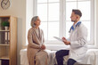 © Studio Romantic - Aged woman consults with doctor rehabilitologist. With compassion and expertise man doctor physician guides aged woman through her medical concerns Aged woman visiting doctor rehabilitologist