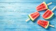 © kevin - Four watermelon popsicles arranged on blue painted wooden surface