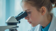© KeetaKawee - Young Scientist Observing Sample Through Microscope in Laboratory Environment with Soft Natural Lighting