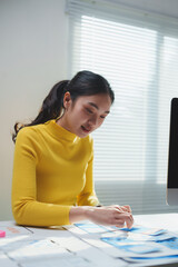 Wall Mural - young professional web designer working on new mobile application and pointing at some detail on pri