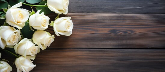 Fototapete - Elegant bouquet of white roses arranged on a dark wooden table with green leaves and ample copy space on the right for text placement