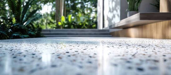 Poster - Polished terrazzo flooring in a modern entryway surrounded by greenery with soft natural lighting showcasing intricate stone patterns.