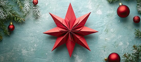 Poster - Red paper star ornament centerpiece on a textured teal background, surrounded by green pine branches and shiny red Christmas balls.